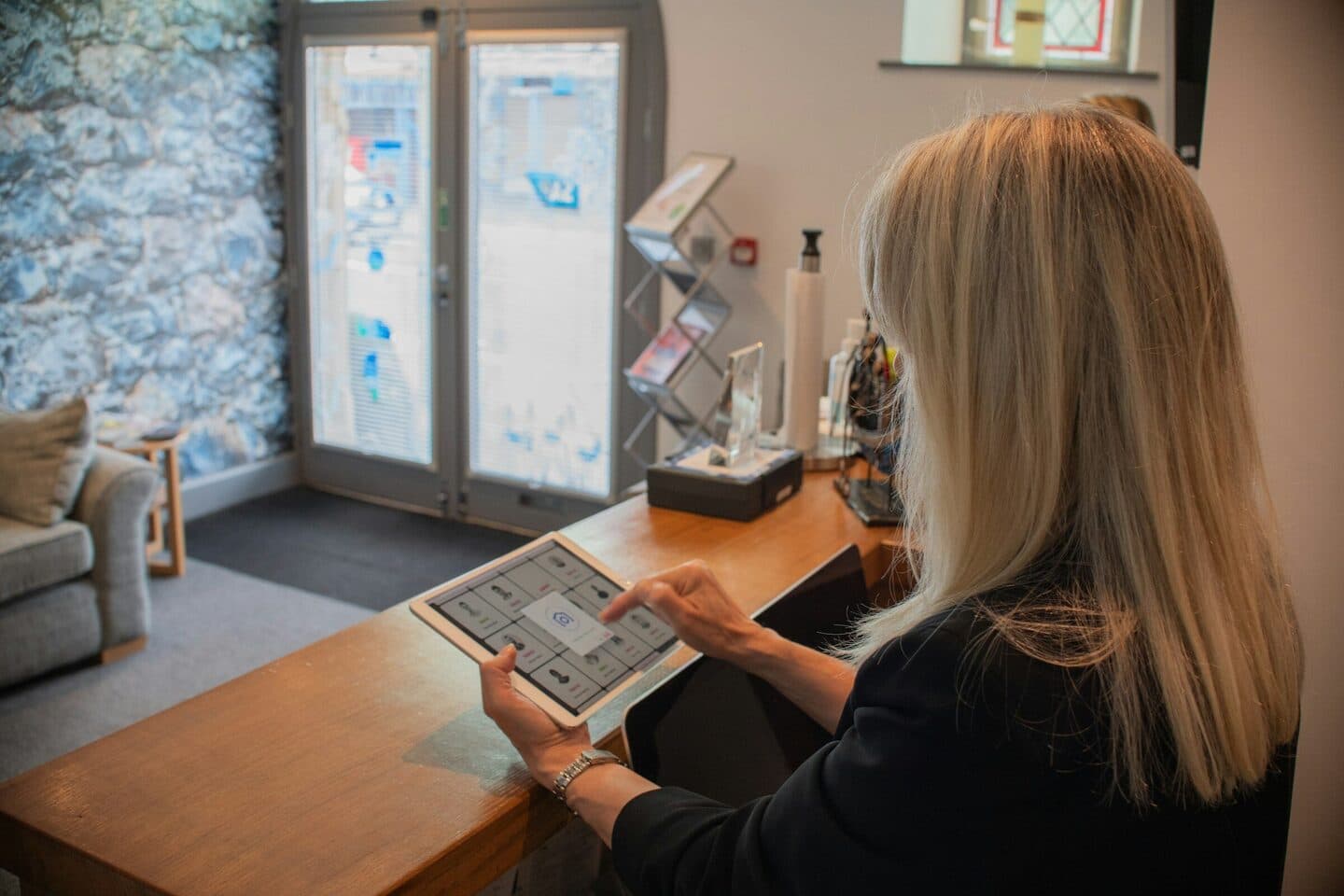 Woman at a reception desk tapping on a tablet