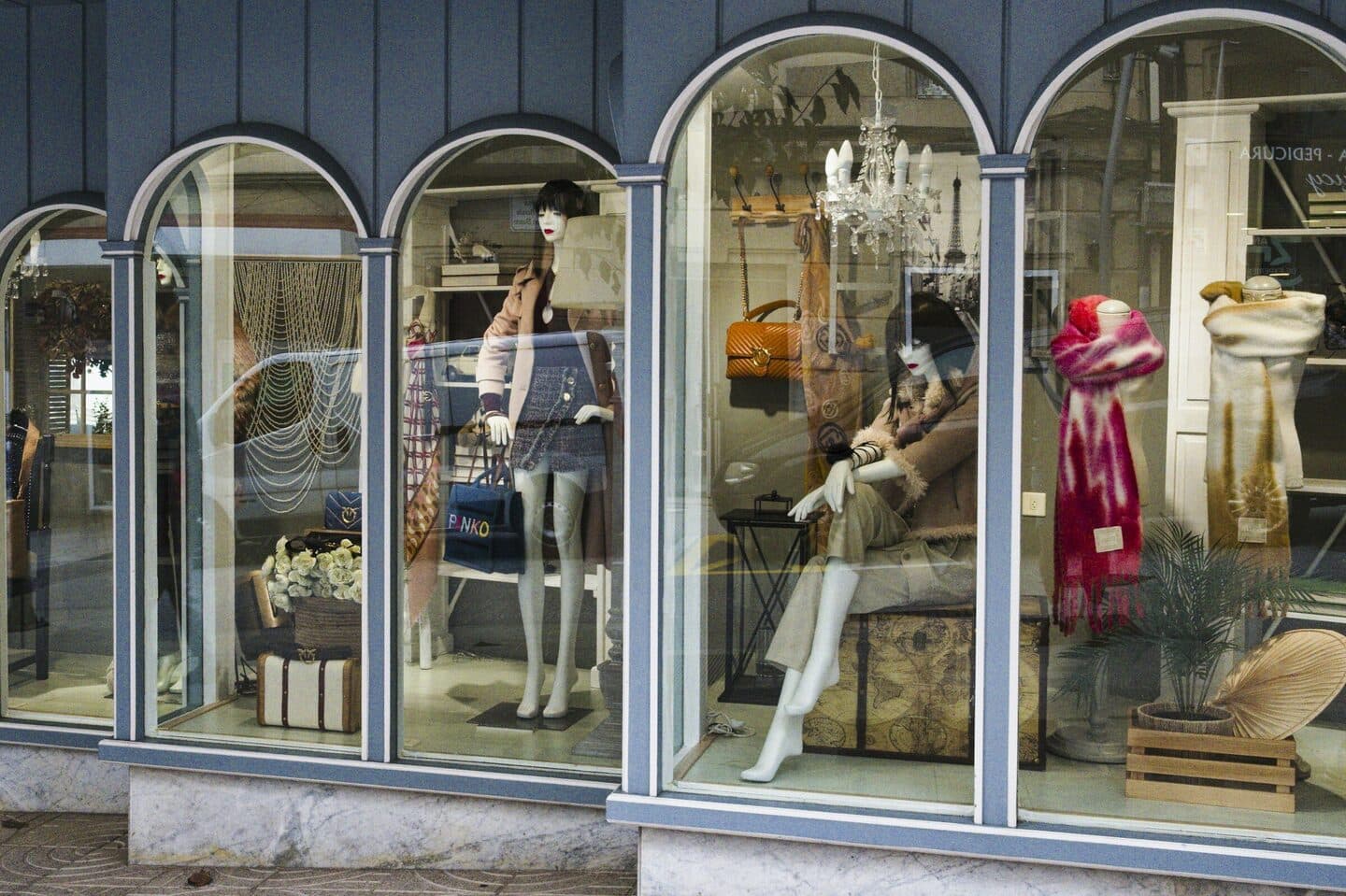 Boutique shop window with arches, mannequins and handbags