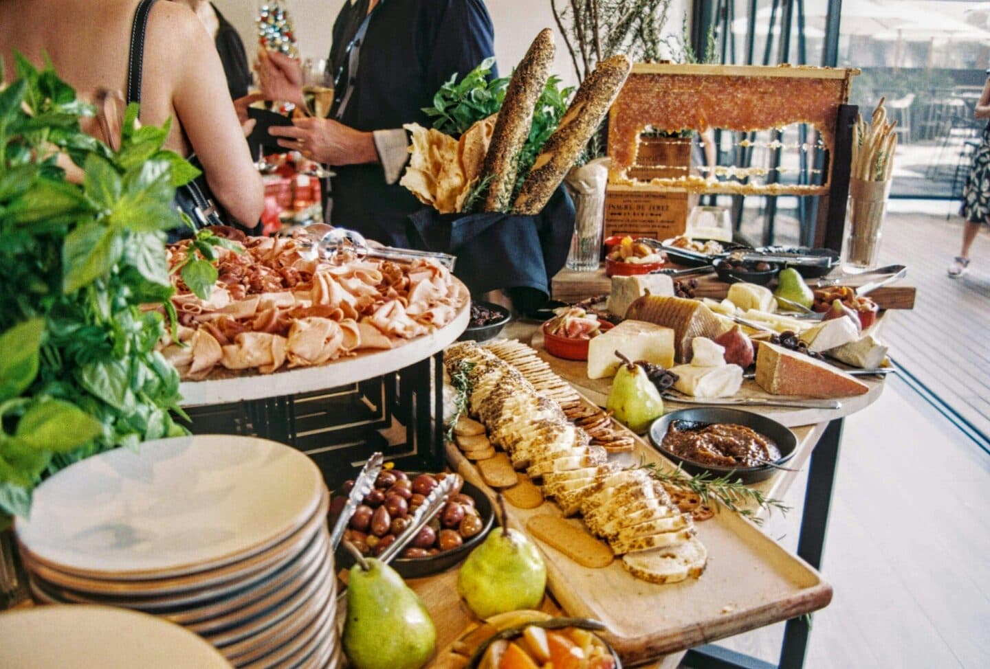 Guests help themselves at a buffet with bread, cheese and cold cuts